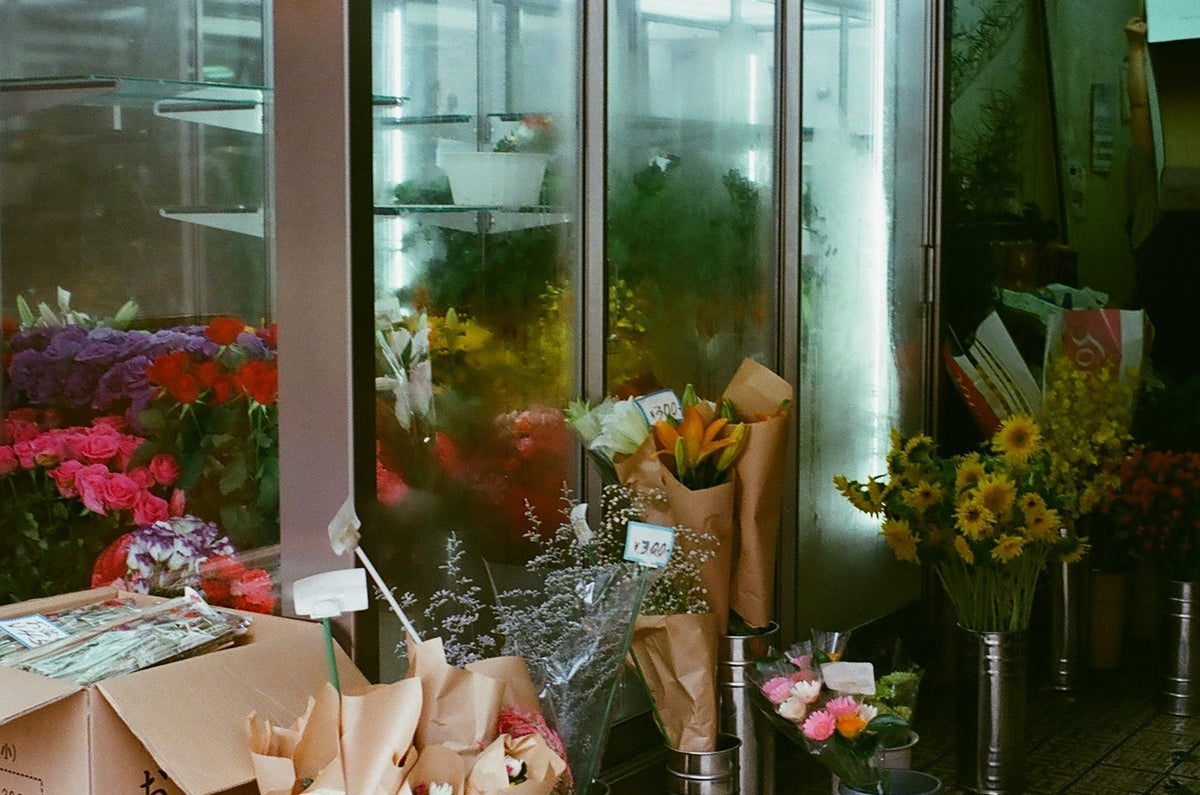 Glass door flower display fridges with buckets of fresh flowers in front