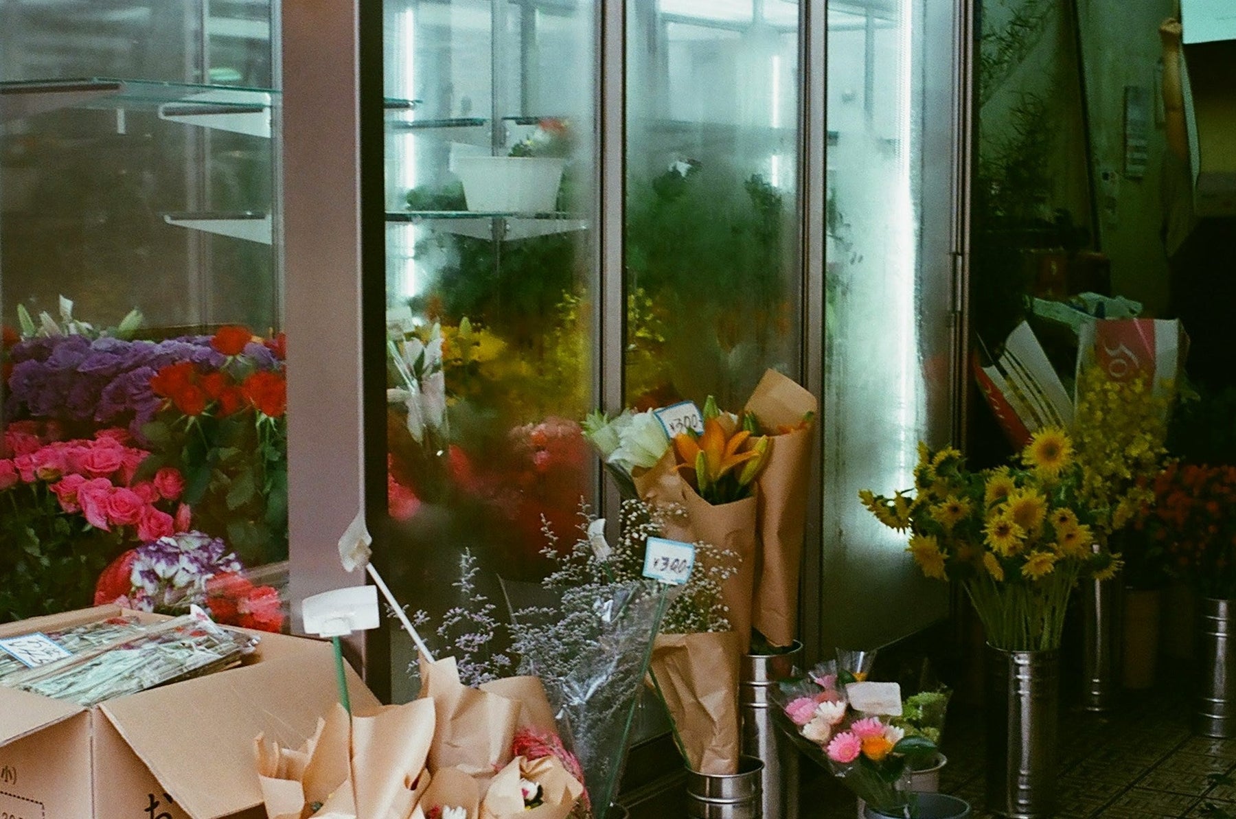 Glass door flower display fridges with buckets of fresh flowers in front